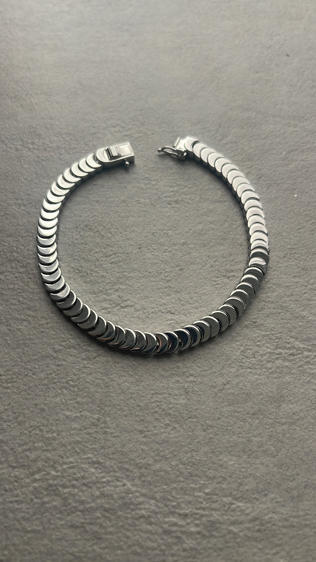 Silver bangle with a tennis bracelet clasp