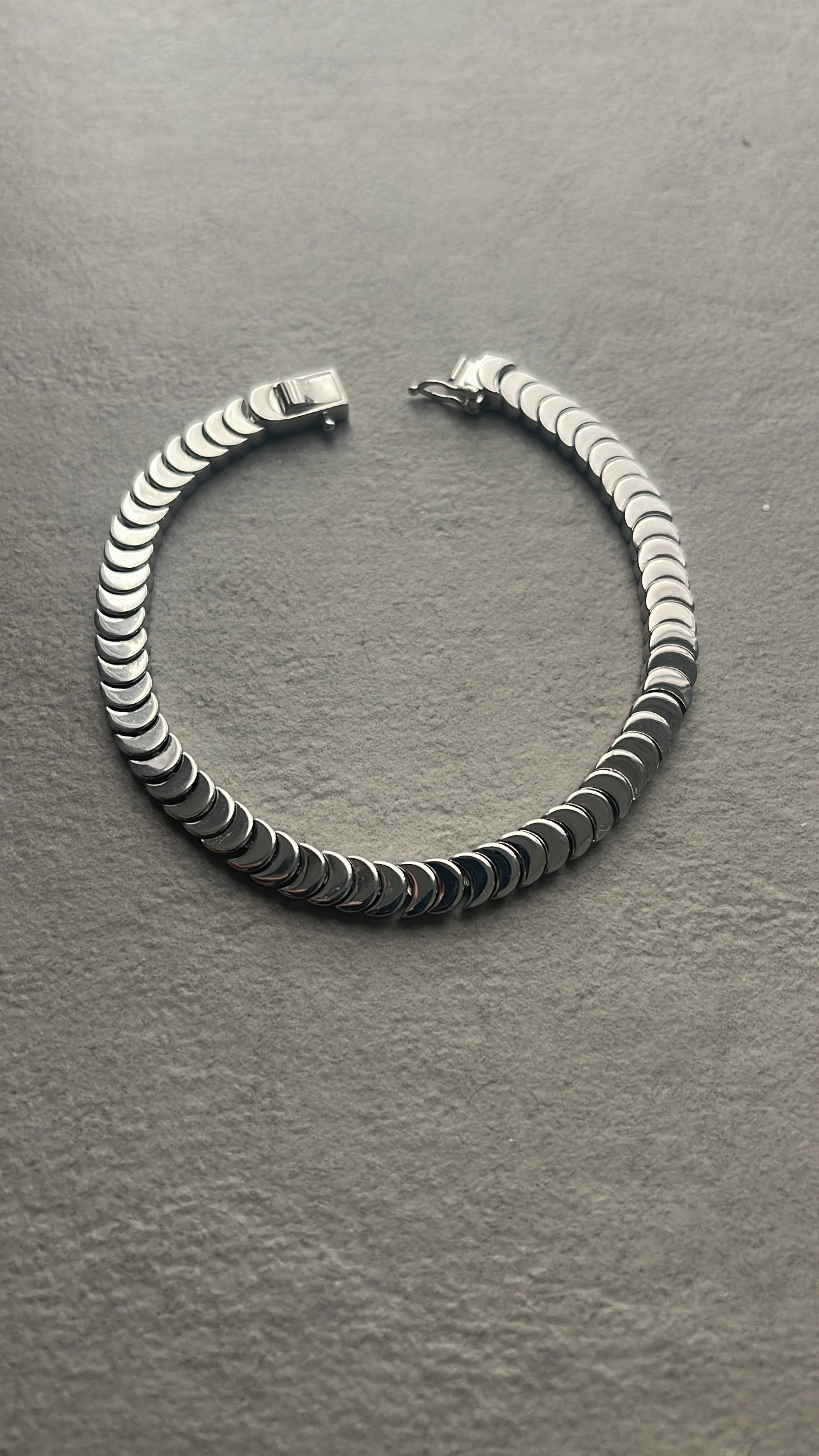 Silver bangle with a tennis bracelet clasp
