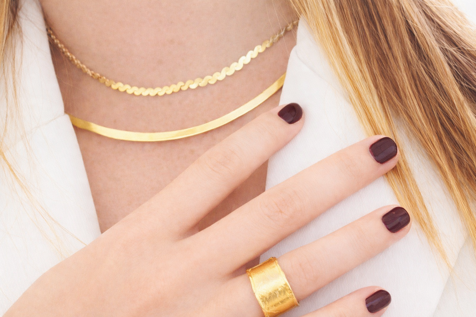Close-up of a hand wearing a gold ring with a blurred background